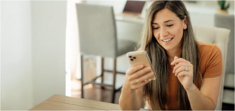 mujer con celular en la mano mirando la app de UTE clientes